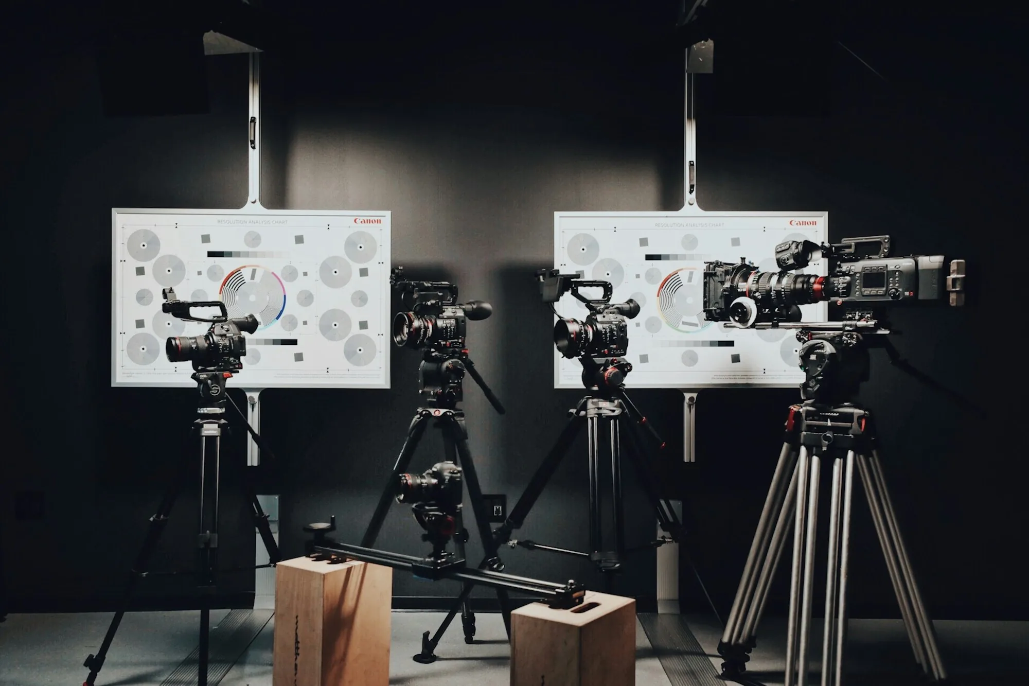 Two professional video cameras on tripods in a quiet studio space