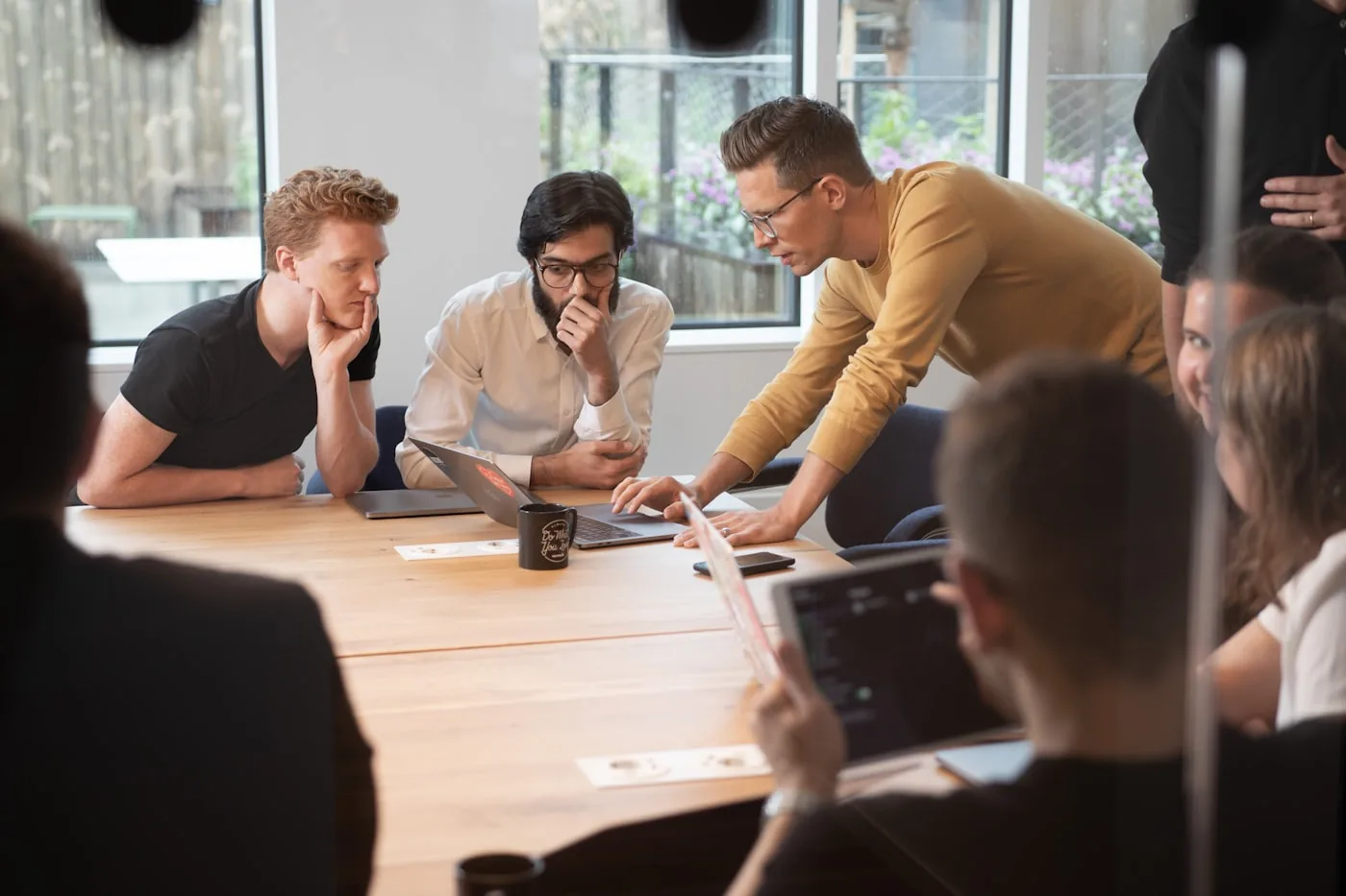 Colleagues in discussion around a wooden table