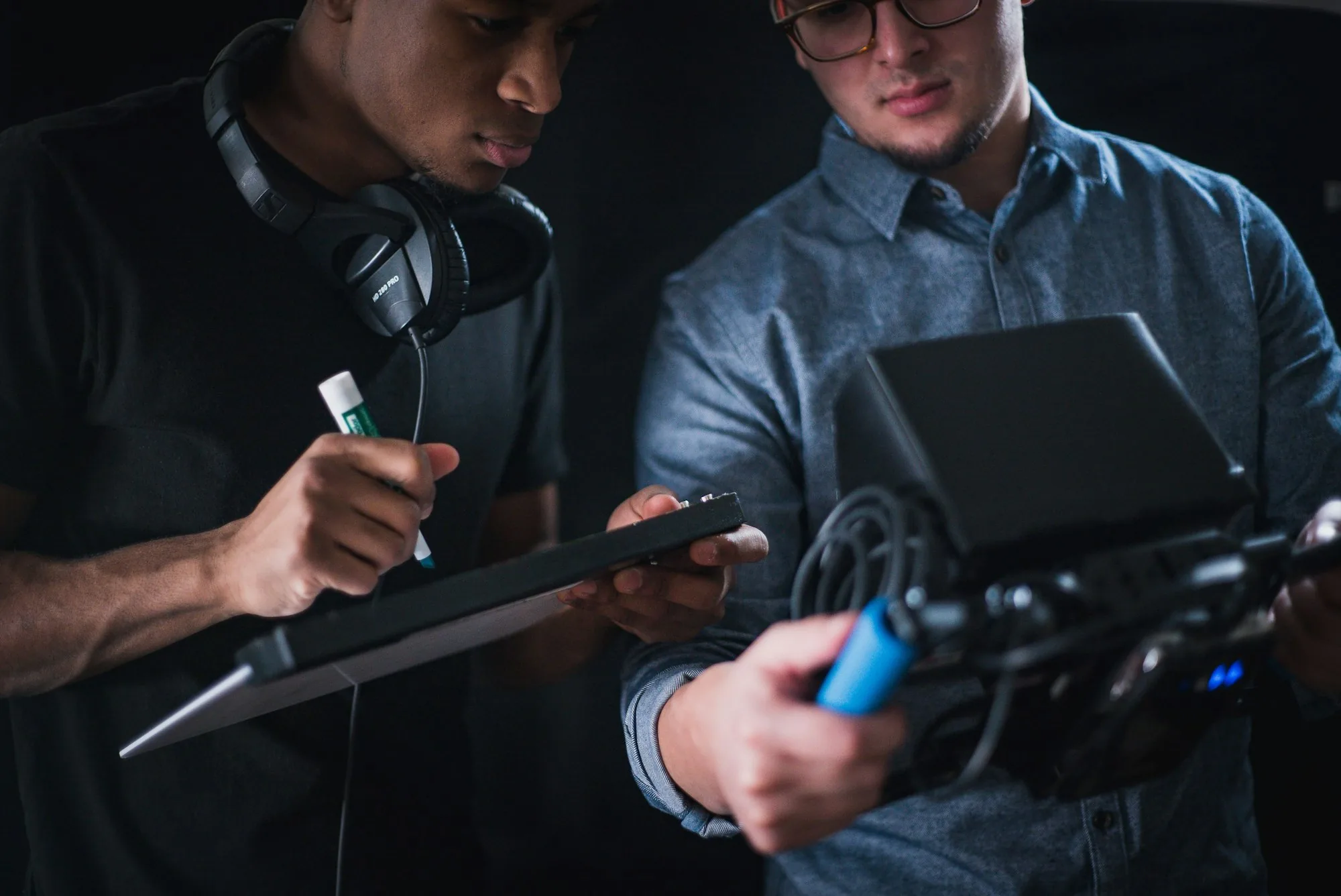Two production crew members reviewing shot notes beside a camera rig