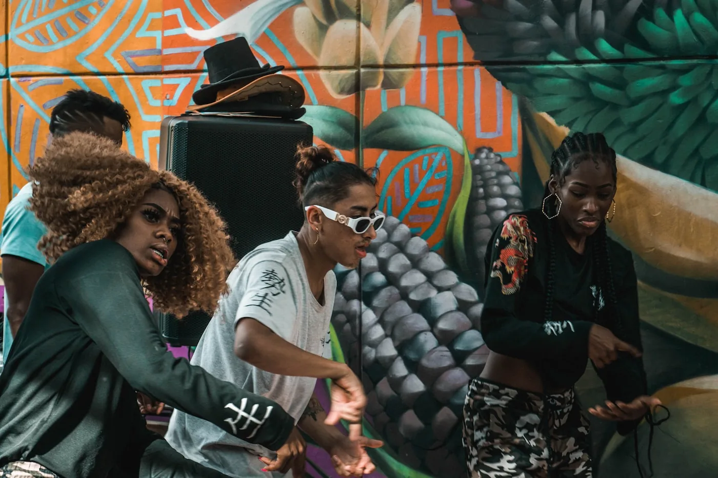 Young creatives gathered in front of a large painted mural