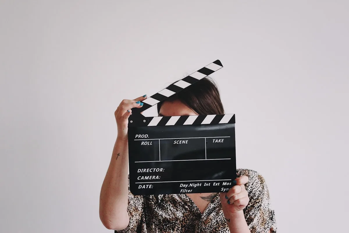 A person holding a clapperboard in front of their face