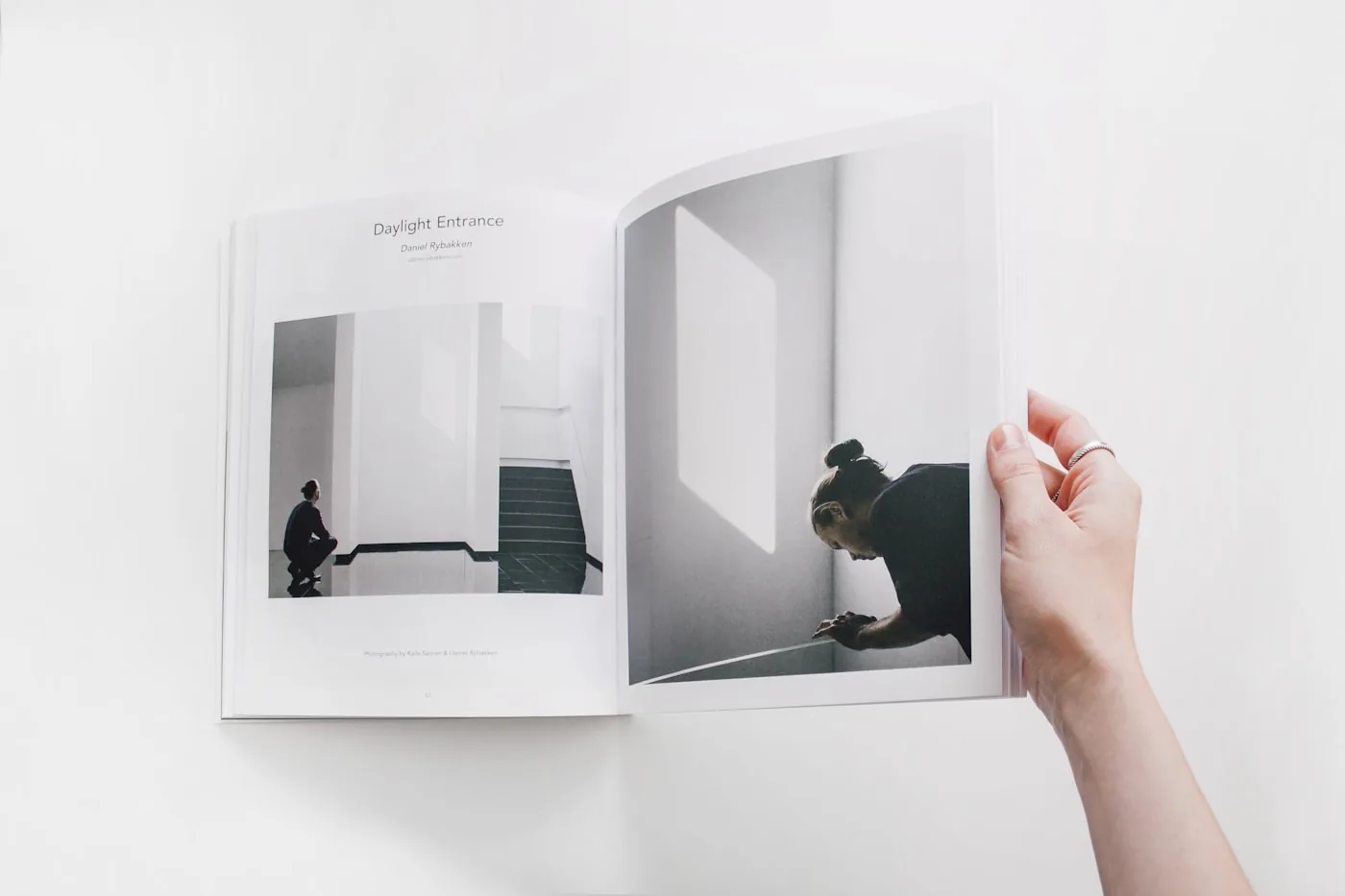 A hand holding open a printed editorial spread