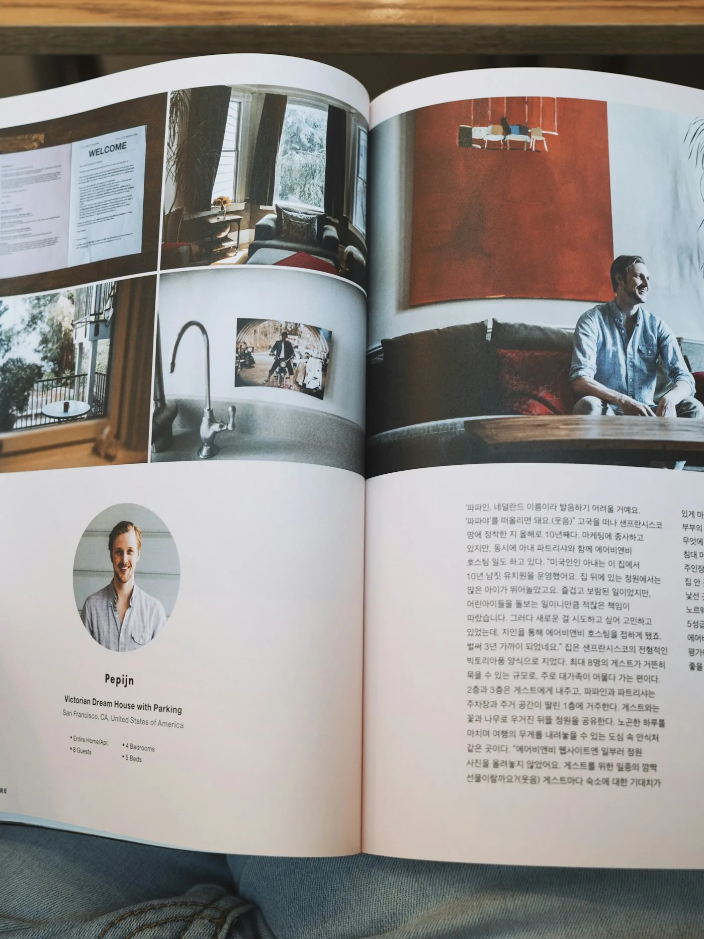 A reader holding open a magazine profile page with photographs and text