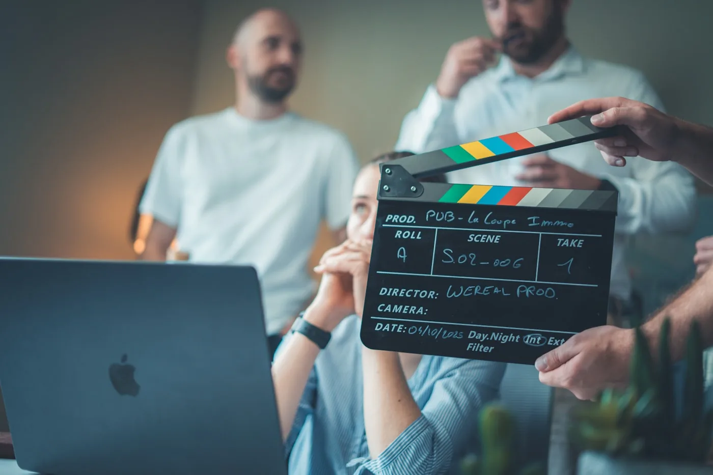A clapperboard held up beside a laptop during a production planning session